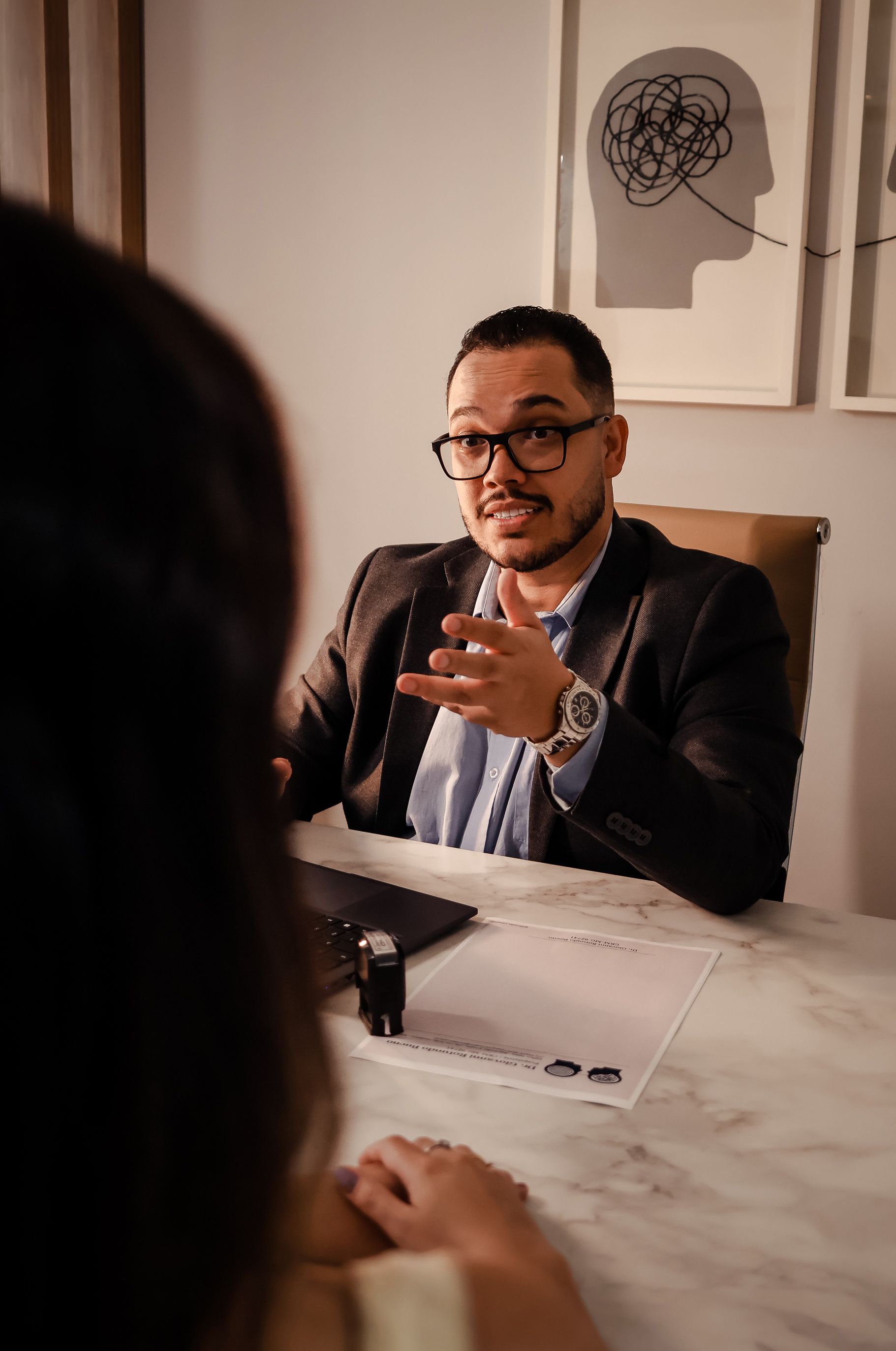 Dr. Giovanni Rotundo Bueno em consulta no consultório em Varginha, conversando com uma paciente